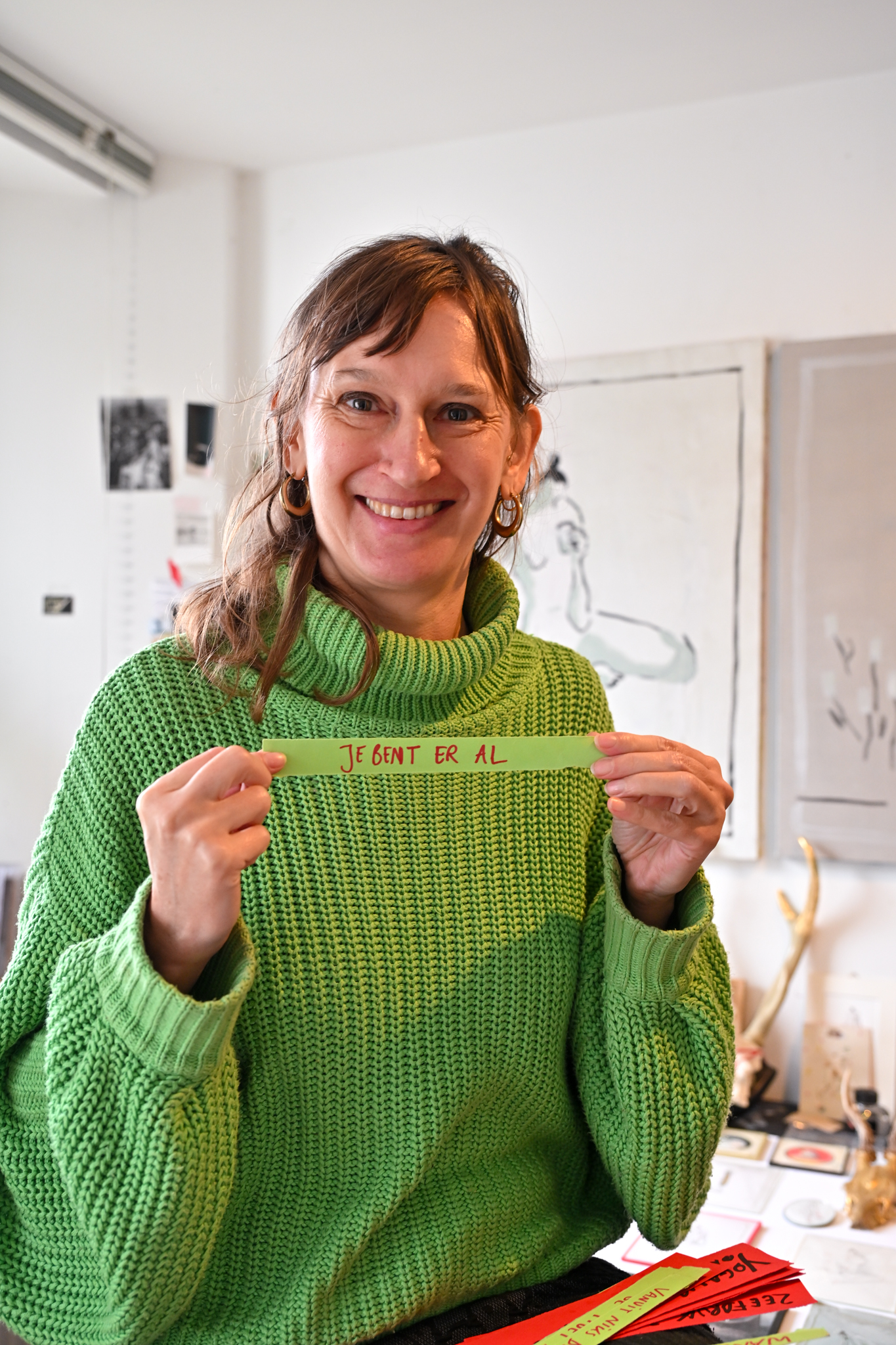 Sabien holding a piece of paper that reads "Je bent er al": "You are already there", a statement that is very meaningful to her. (Photo Zana Langbeen)
